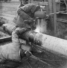 Two welders at work on the Mersey oil pipeline, 24/09/1967. Creator: John Laing plc