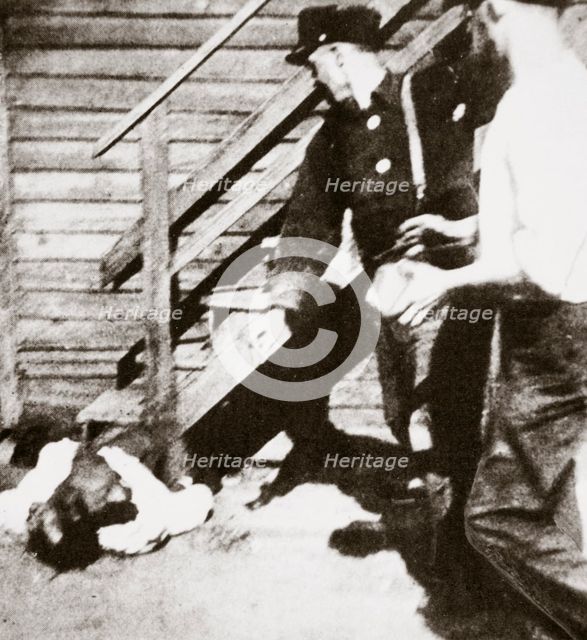 Two white men stoning an African American to death, 1919.  Creator: Unknown.