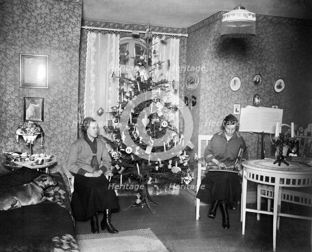 Two women on Christmas Eve with a Christmas tree in front of the window, Sweden, early 1900s. Artist: Unknown