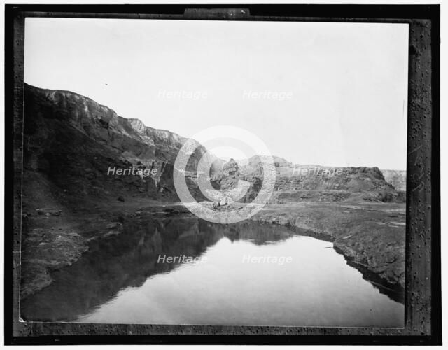 Two women by water, rocky cliffs in background, between 1900 and 1906. Creator: Unknown.