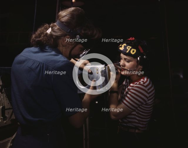 Two women employees of North American Aviation, Incorporated, assembling a section of a..., 1942. Creator: Alfred T Palmer.