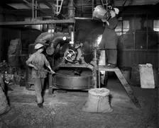 Two women filling Sirocco roaster with coffee beans, J Lyons and Co, London, July 1918. Artist: Adolph Augustus Boucher