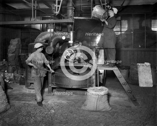 Two women filling Sirocco roaster with coffee beans, J Lyons and Co, London, July 1918.  Artist: Adolph Augustus Boucher.