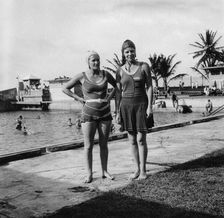 Two women in swimsuits beside a swimming pool, Balboa, Panama, 1931