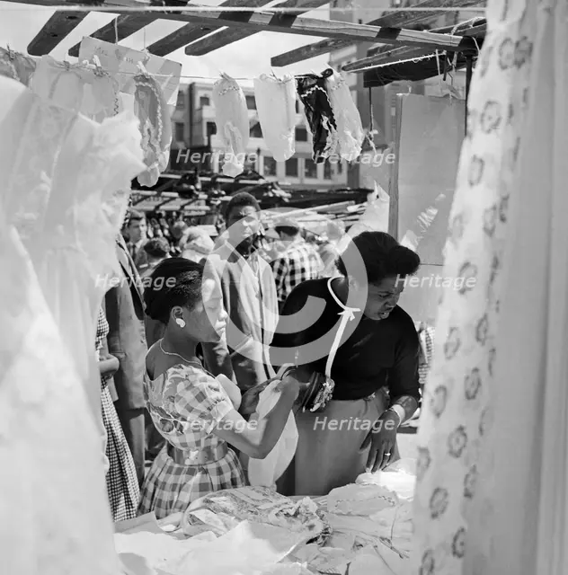 Two women looking at a stall in the Petticoat Lane Market, Whitechapel, London, c1946-c1959. Artist: John Gay