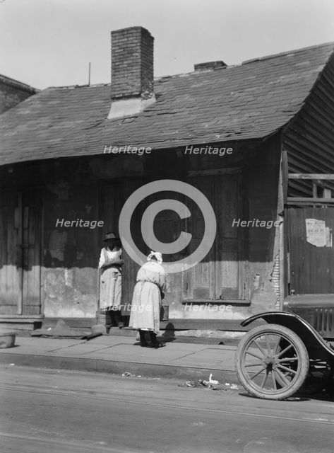 Two women standing in or by a doorway, New Orleans, between 1920 and 1926. Creator: Arnold Genthe.