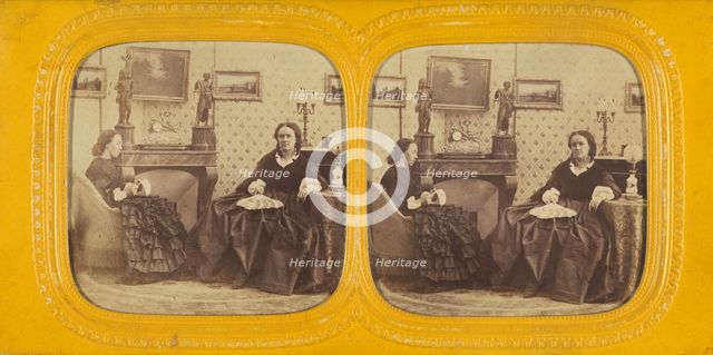 Two women seated in a parlor, one is sewing, the other with a hand fan in her lap, 1860s. Creator: E Lamy.