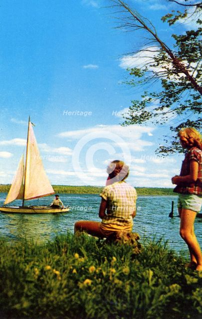 Two women watching a sailing boat on a lake, Michigan Water Wonderland, USA, 1955. Artist: Unknown