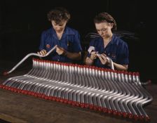Two women workers are shown capping and inspecting tubing...Vultee's Nashville..., Tennessee, 1943. Creator: Alfred T Palmer