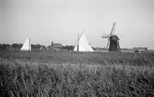 Two yachts under sail seen over the reed beds near East Tunstall Mill, Norfolk, 1934. Artist: HES Simmons