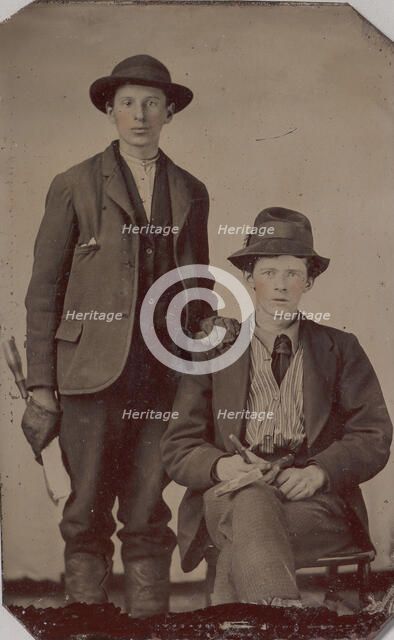 Two Young Men, One Seated and One Standing, Holding Carpentry Tools, 1870s-90s. Creator: Unknown.