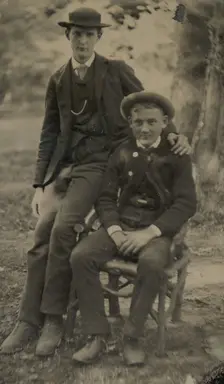 Two Young Men Outdoors, One Seated, the Other on the Arm of the Chair, 1880s. Creator: Unknown