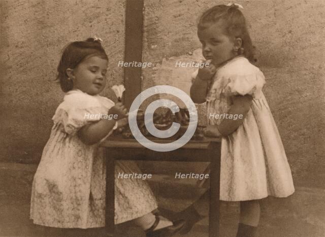 'Two young girls by a table', 1937.  Artist: Unknown.