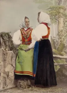 Two young women pose in folk costumes, with dotted headdresses, 1886-1890. Creator: Helene Edlund
