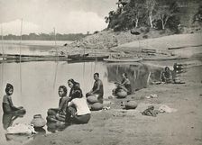Typical Riverside Scene on the great Irrawaddy - Women bathing and drawing water 1900. Creator: Unknown