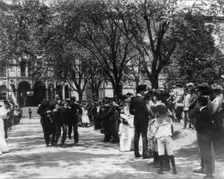 U.S. Naval Academy, Annapolis: 4 midshipmen carrying a man; crowd of guests along sidewalk, (1902?). Creator: Frances Benjamin Johnston