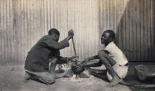 Umtali, Zimbabwe: two African boys stirring a cooking pot, 1905. Creator: J Lomas