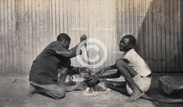 Umtali, Zimbabwe: two African boys stirring a cooking pot, 1905. Creator: J Lomas.
