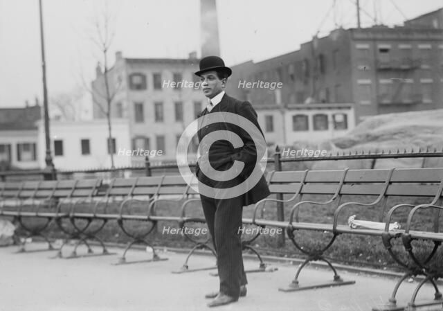 Umberto Blaisie standing in front of park benches, 1910. Creator: Bain News Service.