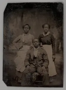 Untitled (Portrait of Two Standing Women and One Seated Man), 1880. Creator: Unknown