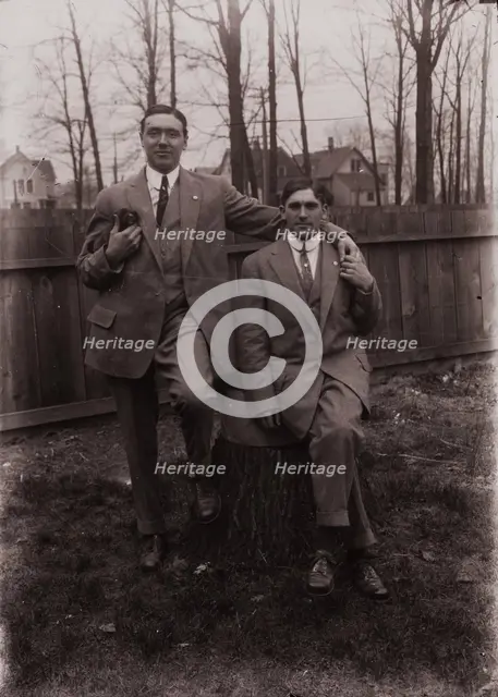 Untitled (two men holding small dog; one sitting on a stump, Fisher St., backyard), c1915. Creator: Wendell Hotter.