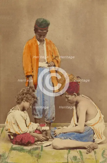 Unidentified man with basket standing, plus two boys seated playing cards, 1865-1870. Creator: Giorgio Conrad.