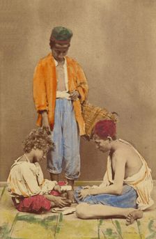 Unidentified man with basket standing, plus two boys seated playing cards, 1865-1870. Creator: Giorgio Conrad