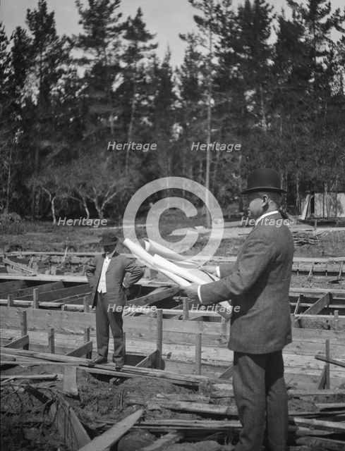 Unidentified man at a construction site studying building plans, between 1896 and 1942. Creator: Arnold Genthe.