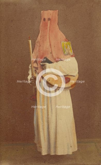 Unidentified man in long hood holding a candle and book, standing, about 1870. Creator: Giorgio Conrad.