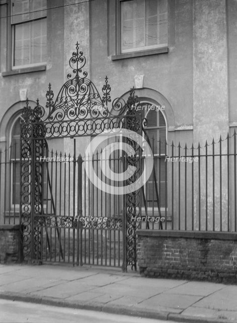 Unidentified building behind a fence, New Orleans or Charleston, South Carolina, c1920-1926. Creator: Arnold Genthe.