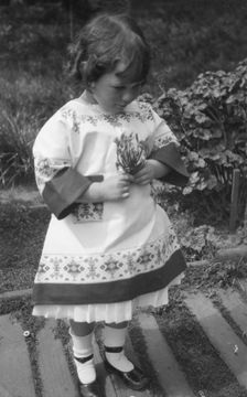Unidentified child, standing outdoors, between 1911 and 1942. Creator: Arnold Genthe