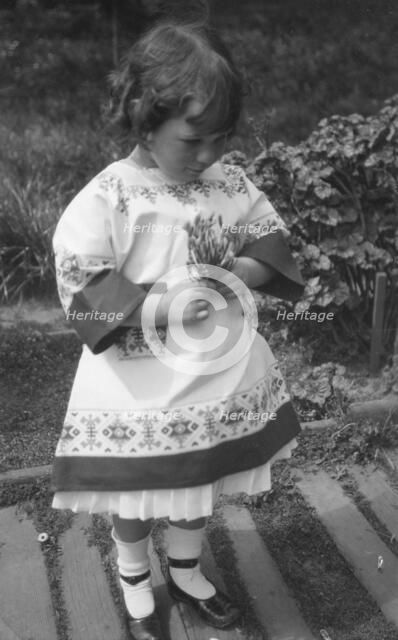 Unidentified child, standing outdoors, between 1911 and 1942. Creator: Arnold Genthe.