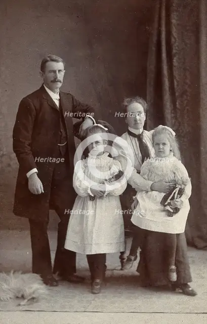 Unidentified family with two girls holding dolls. Creator: Priyalalls Photography.