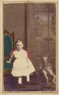 Unidentified little girl standing with a dog on the floor next to her, 1865-1875. Creator: Bent