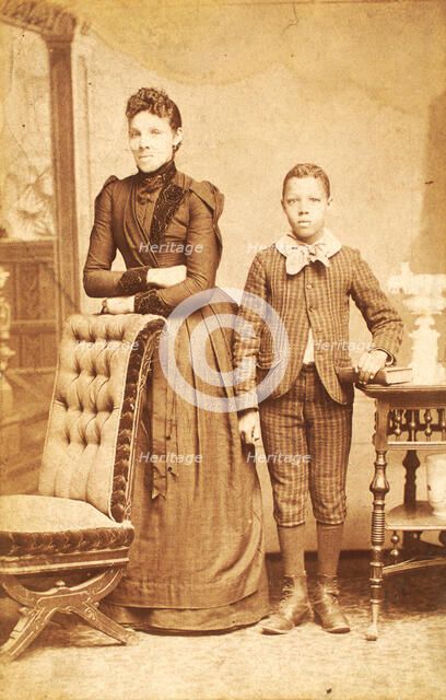 Unidentified standing figures: woman, her folded arms leaning on back of chair..., 1890. Creator: J. N. Wilson.