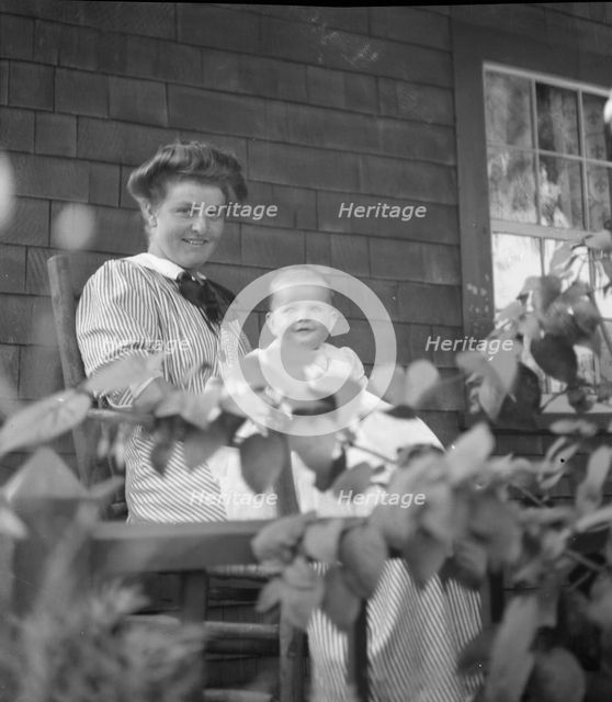 Unidentified woman and baby, seated on porch, between 1911 and 1942. Creator: Arnold Genthe.