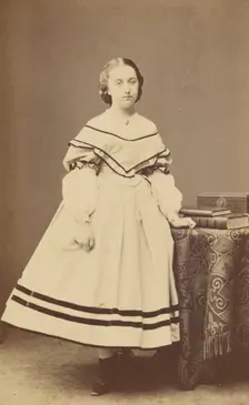 Unidentified woman standing near a table with books on top, 1865-1875. Creator: Bayard & Bertall