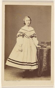 Unidentified woman standing near a table with books on top, 1865-1875. Creator: Bayard & Bertall