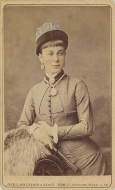 Unidentified woman standing, holding a fan, 1879. Creator: David Rees & Brother & Son