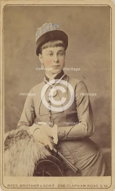 Unidentified woman standing, holding a fan, 1879. Creator: David Rees & Brother & Son.