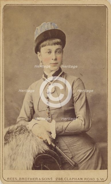Unidentified woman standing, holding a fan, 1879. Creator: David Rees & Brother & Son.