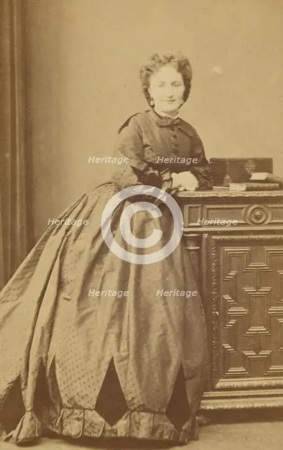 Unidentified woman standing, leaning against a credenza, about 1861. Creator: Bayard & Bertall.