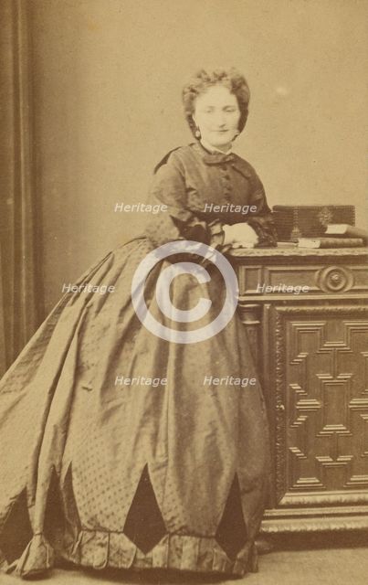 Unidentified woman standing, leaning against a credenza, about 1861. Creator: Bayard & Bertall.
