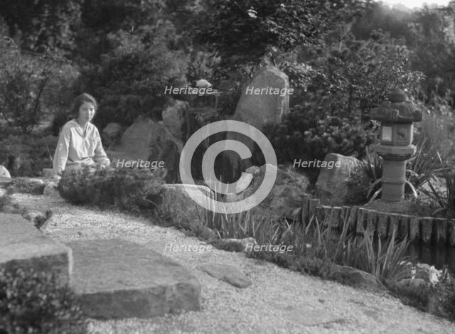 Unidentified woman seated in a garden next to a stream, possibly belonging to A.W. Bahr, c 1917-1934 Creator: Arnold Genthe.