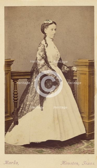 Unidentified woman wearing a white dress and black shawl, standing, 1870-1875. Creator: H. R. Marks.