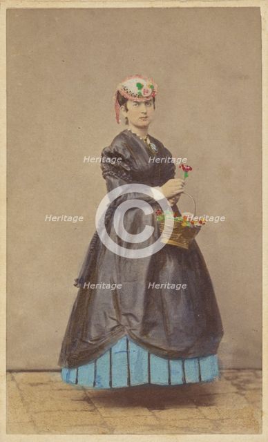 Unidentified woman wearing a flowered hat, holding single flower in one hand, basket of...1862-1865. Creator: Carlo Ponti.