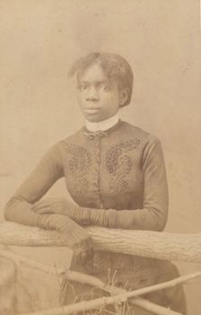 Unidentified young woman wearing gloves, leaning on prop fence, c1880. Creator: H. A. Insley
