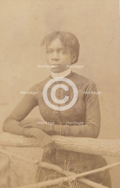 Unidentified young woman wearing gloves, leaning on prop fence, c1880. Creator: H. A. Insley.