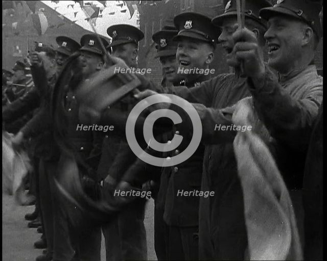 Uniformed British Soldiers Cheering and Smiling Whilst Waving Flags, 1937. Creator: British Pathe Ltd.