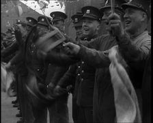 Uniformed British Soldiers Cheering and Smiling Whilst Waving Flags, 1937. Creator: British Pathe Ltd